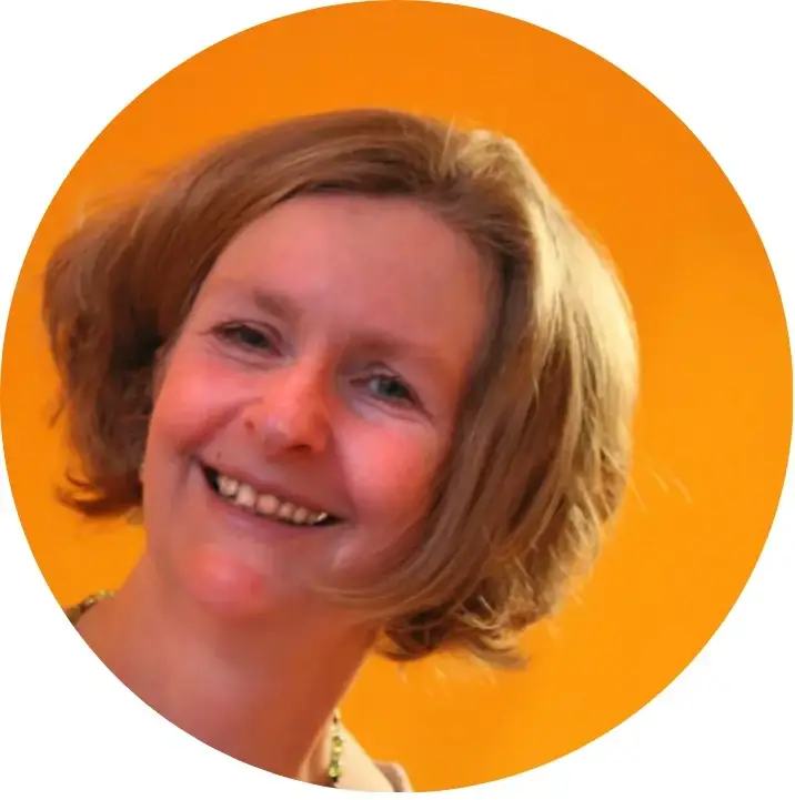 Claudia, Yoga-Lehrerin bei Yoga am Ufer in Landau, strahlend vor orangefarbenem Hintergrund.